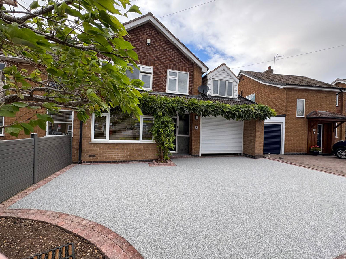 Beautiful silver resin driveway with red block paving border to a home in Leicestershire