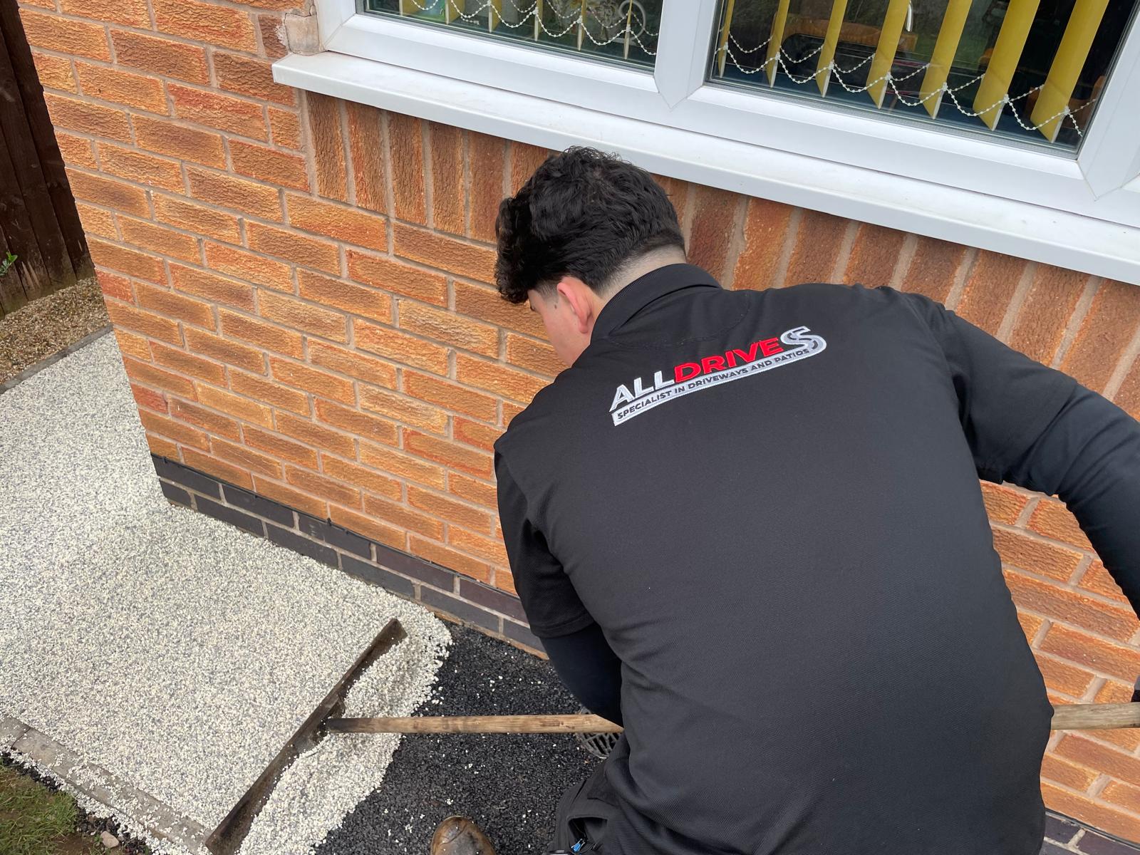 Installing granite resin driveway. Raking resin to 30mm correct depth before trowelling.