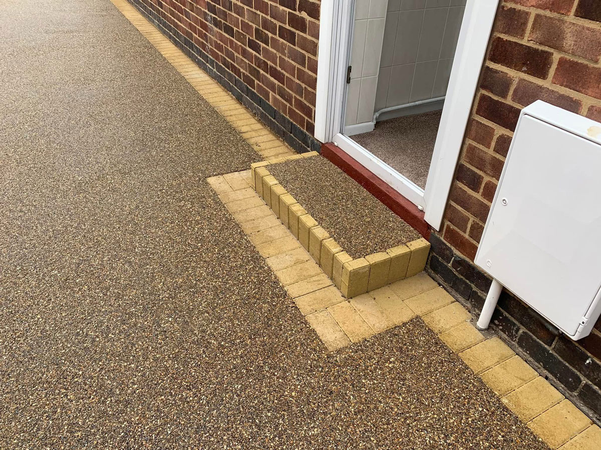 Amber Gold Resin Driveway in Loughborough with grey block paving border. 150mm MOT Sub-base with 50mm Porous Tarmac. Finished in 30mm silver resin.